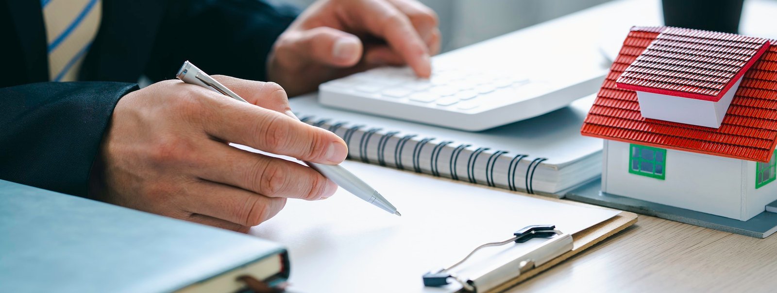 real estate agent with House model and customer discussing for the contract to buy house, insurance